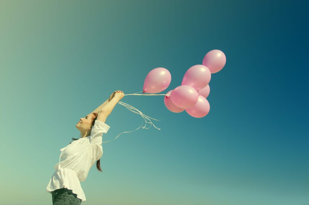 beautiful woman with colorful balloons outside