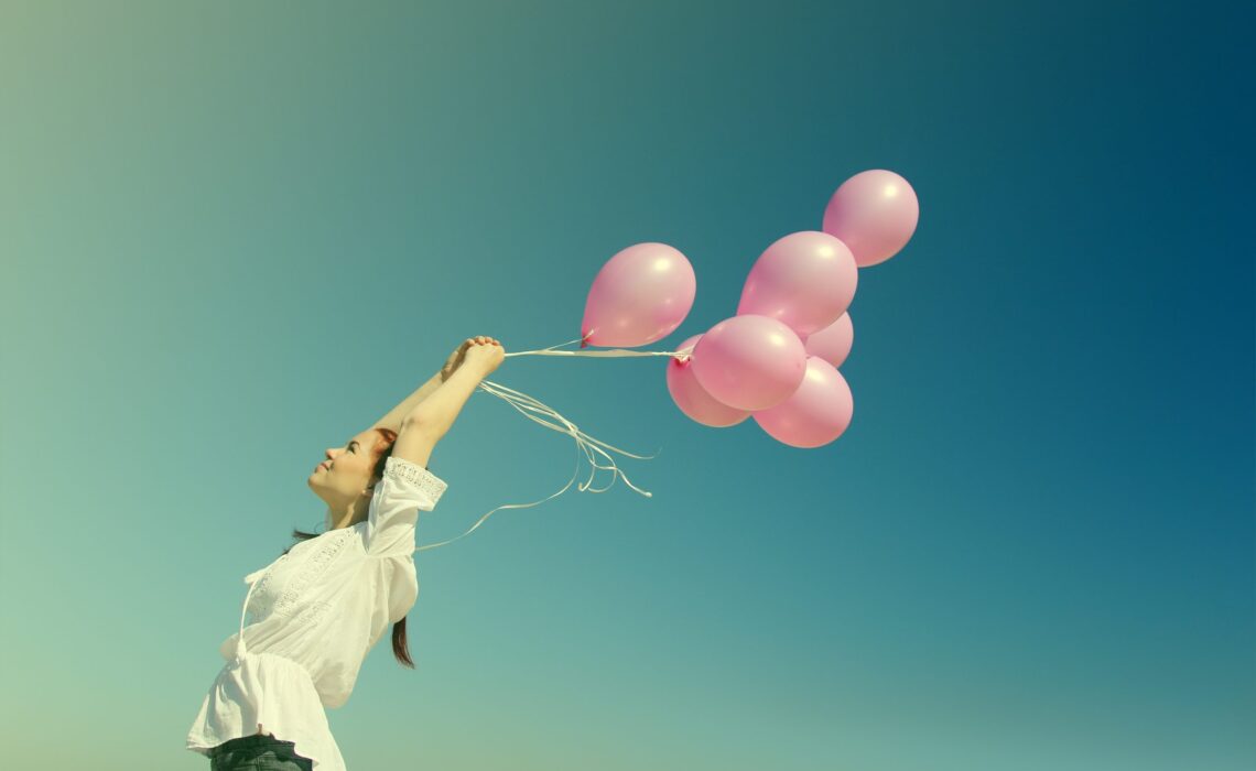 beautiful woman with colorful balloons outside